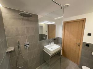塞纳莱斯Dorfblick Appartements & Rooms的一间带水槽和淋浴的浴室