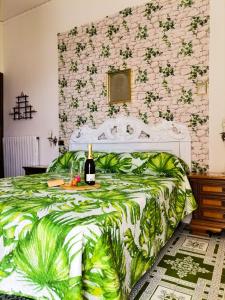 阿特拉尼弗朗西斯之家酒店的一间卧室配有一张床,并备有一瓶葡萄酒