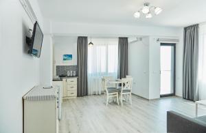 北马马亚-讷沃达里Apartments Excelsior Mamaia Nord的一间厨房,里面配有桌椅