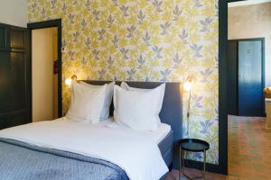Raissac-dʼAudeLogement Onze Chambres & Gîtes的卧室配有带白色枕头和壁纸的床