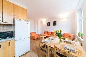 弗罗茨瓦夫Przyjazne mieszkanie w kamienicy blisko centrum的厨房以及带桌子和白色冰箱的用餐室。