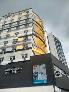 里约热内卢B&B HOTEL Rio de Janeiro Norte的一座高大的建筑,旁边有一个标志
