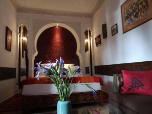 马拉喀什东方魅力摩洛哥住宅酒店 - 仅限成人的一间卧室配有床和花瓶