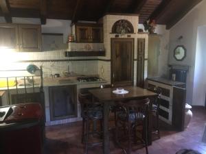 VeccialoneLa Cella Lizzano的厨房配有木桌和一些椅子