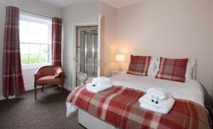 ChirnsideTHE Waterloo Arms Hotel的一间卧室配有带毛巾的床
