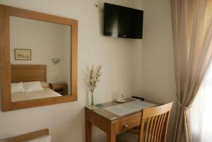 马拉加戈阿廷酒店的一间卧室配有桌子、镜子和一张床