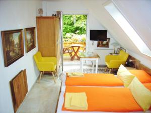 巴特多布兰Ostsee Hotel-Pension An der Lindenallee的一间卧室配有橙色的床和黄色的椅子