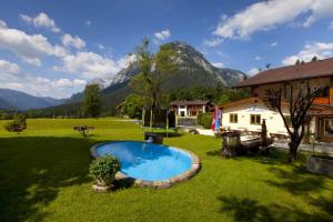 拉姆绍白特朗旅馆的一个带游泳池的庭院,有房子和山脉