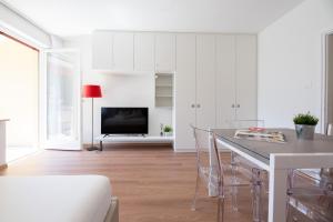 梅拉诺Fior Apartments Pienzenau的白色的客厅配有桌子和电视