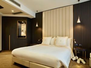 维泰博Hotel Niccolo' V - Terme dei Papi的卧室配有带白色枕头的大床