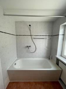 达豪Olympia Pension的带淋浴的浴室配有白色浴缸。