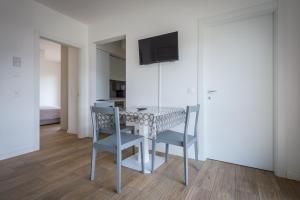 卢加诺Modern apartment in Lugano的一间带桌子和两把椅子的用餐室