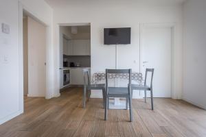 卢加诺Modern apartment in Lugano的一间带桌椅的用餐室和一间厨房
