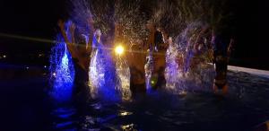 布什泰尼维拉阿鲁尼斯酒店的一群人晚上在喷泉里玩耍
