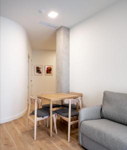 毕尔巴鄂Apartamentos Líbere Bilbao La Vieja的客厅配有桌子和沙发