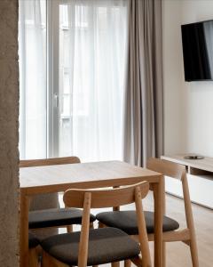 毕尔巴鄂Apartamentos Líbere Bilbao La Vieja的窗户客房内的一张木桌和椅子