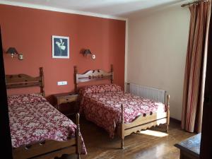 莱昆韦里阿耶斯塔兰一号旅馆的红色墙壁客房的两张床