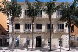 布林迪西Maria Vittoria Charming Rooms and Apartments的一座棕榈树建筑