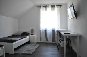BurgriedenB Home SLEEP & WORK的一间卧室配有一张床、一张书桌和一个窗户。