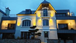 瓦讷Appart hôtel & Spa La Villa du Port的前面有一棵树的白色房子