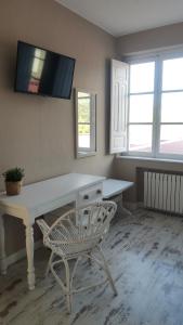 NavecesHotel Román的一间设有白色书桌和椅子的客房