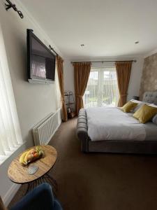 纽里Clanrye House Guest Accommodation的一间卧室配有一张床、一张桌子和一台电视。