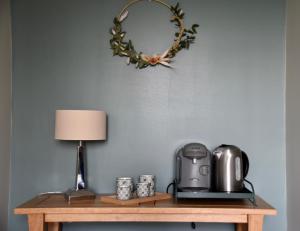 ChampguyonLes Rougemonts Eucalyptus的一张桌子、咖啡壶和墙上花圈