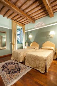 PetrignanoHotel Assisi Parco Dei Cavalieri的一间卧室设有两张床和窗户。