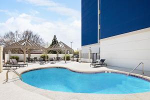 塔克Holiday Inn Express & Suites - Atlanta - Tucker Northlake, an IHG Hotel的一座带椅子的酒店游泳池以及一座建筑