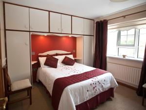 格伦蒂斯阿瓦隆之家住宿加早餐旅馆 的一间卧室设有一张红色墙壁的大床