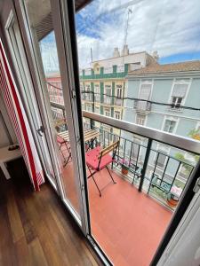 瓦伦西亚Apartamentos Sevilla的阳台设有长凳,享有建筑的景致。