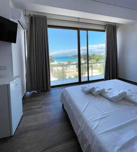 卡萨米尔Hotel Lula Ksamil的酒店客房设有一张床和一个大窗户