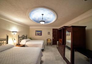 坎佩切Hotel Francis Drake的一间卧室设有两张床和圆形天花板
