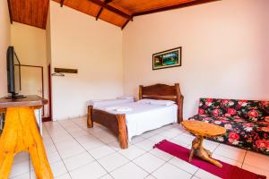 戈亚斯州科伦巴Hotel Fazenda Serra da Irara的一间卧室配有一张床和一张沙发