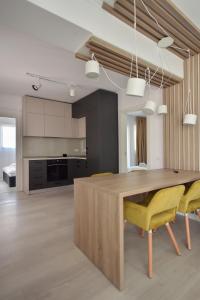 北马马亚-讷沃达里WAVE 3 Promenada Apartments的厨房配有木桌和黄色椅子
