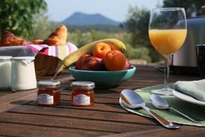 TavernesPantaiaHomes - My Little Garden - Piscine - Vue panoramique的一张桌子,上面放着一碗水果和一杯橙汁