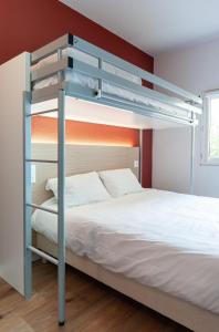 博讷Premiere Classe Beaune的卧室配有带白色床单的双层床