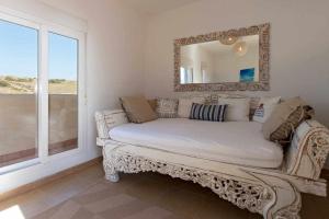 塔里法Tarifa Beach Rentals Aljara的一张沙发,位于带镜子和窗户的房间