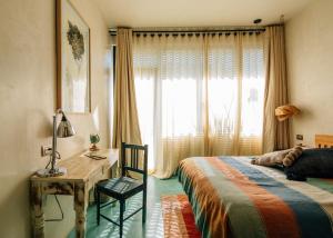 瓦哈卡市Boulenc Bed and Bread的一间卧室配有一张床、一张书桌和一个窗户。