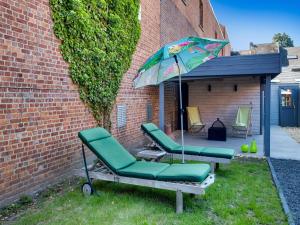 Scherpenheuvel-ZichemModern holiday home in Scherpenheuvel with infrared sauna的院子里的一组椅子和一把伞