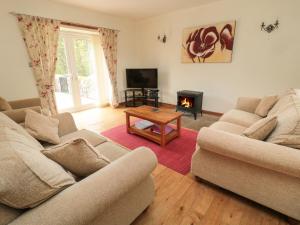 贝尔福德Gardener's Cottage的客厅设有两张沙发和一个壁炉