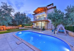 安塔利亚Villa Candan Kaş的房屋前有游泳池的房子