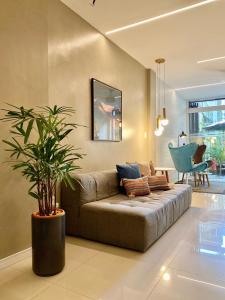 里约热内卢Injoy Suítes & Aparts的带沙发和盆栽植物的客厅