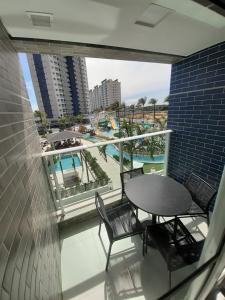 萨利诺波利斯Salinas Exclusive Resort的一个带桌椅的阳台和一个游泳池