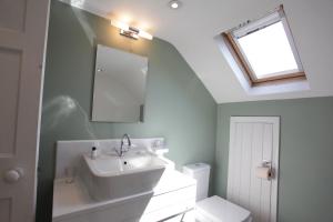 惠特比Thistlebank Townhouse的一间带水槽、镜子和卫生间的浴室