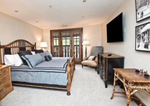 埃文Ascent Residence 309的一间卧室配有一张床、一台电视和一张书桌