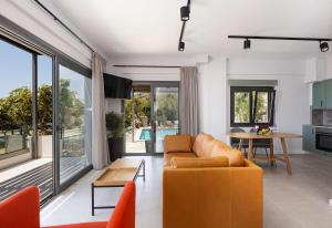 罗达奇诺Anemos Luxury Villas的客厅配有沙发和桌子