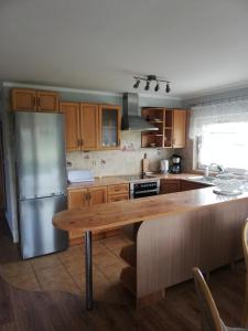 克沃兹科Apartament Bukowy的厨房配有不锈钢冰箱和木桌