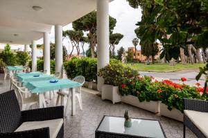萨包迪亚Hotel Il Gabbiano的庭院设有桌椅和鲜花