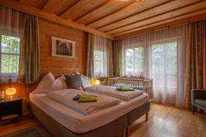 斯拉德明Landhaus Hinteregg Apartment的一间带两张床铺的卧室,位于带木墙的房间内